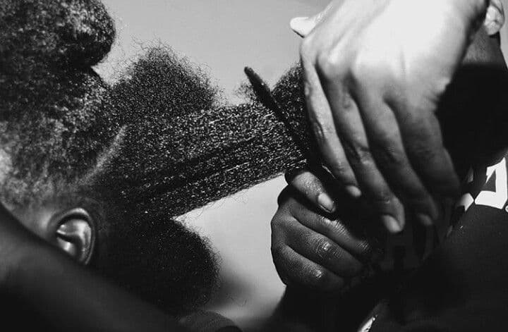 Hands parting and combing natural hair — the ritual in practice