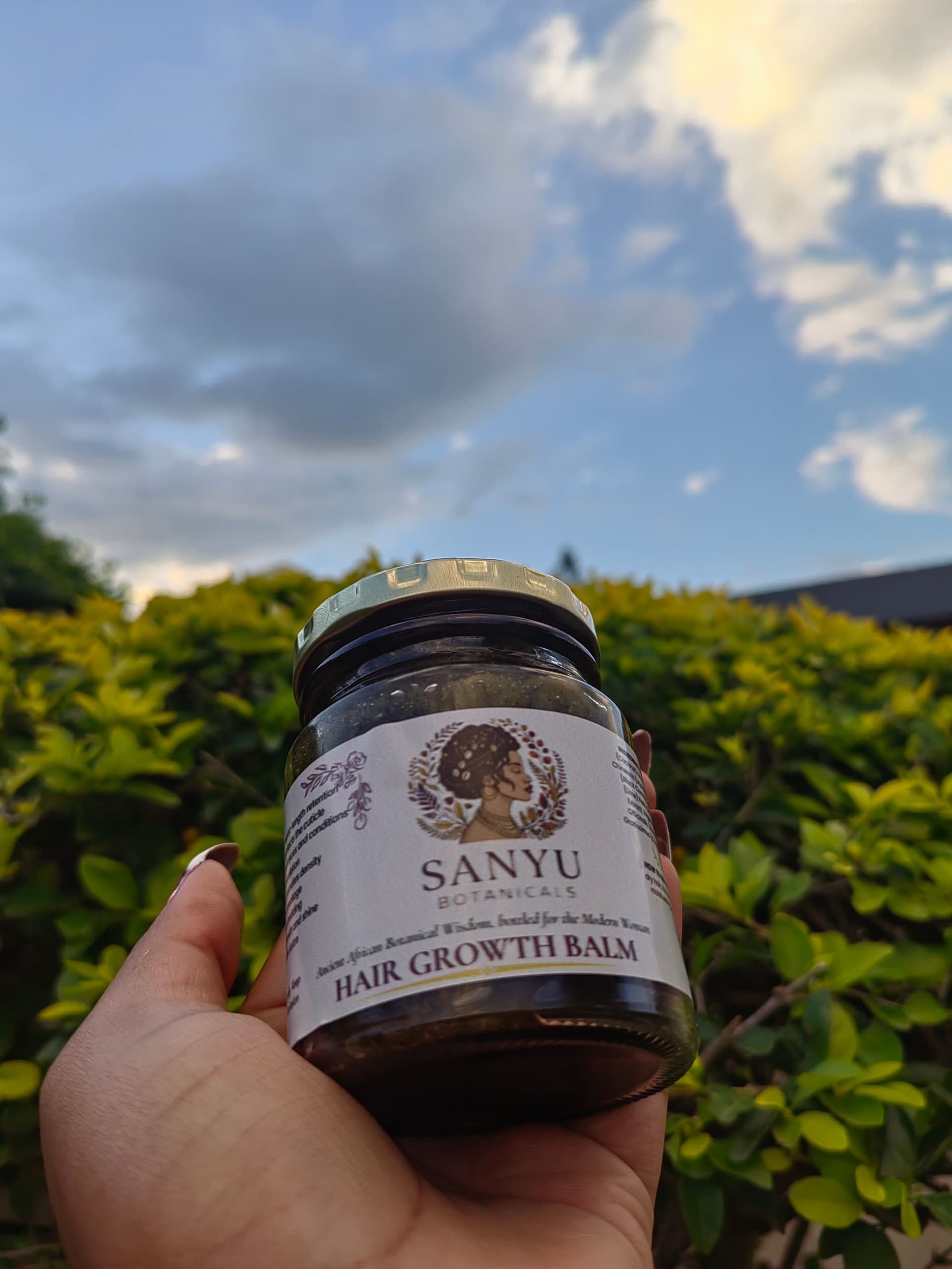 Sanyu Hair Growth Balm — gold lid glass jar in golden light